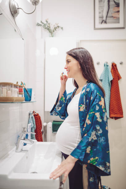 istock At home - young woman brushing her teeth 1153677330