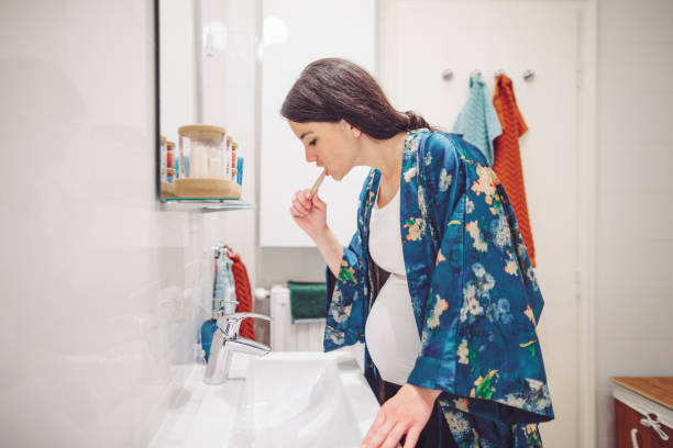 At home - young woman brushing her teeth stock photo