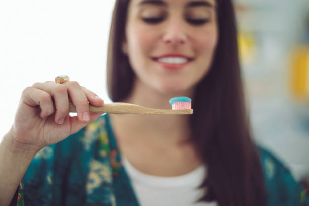 At home - young woman brushing her teeth