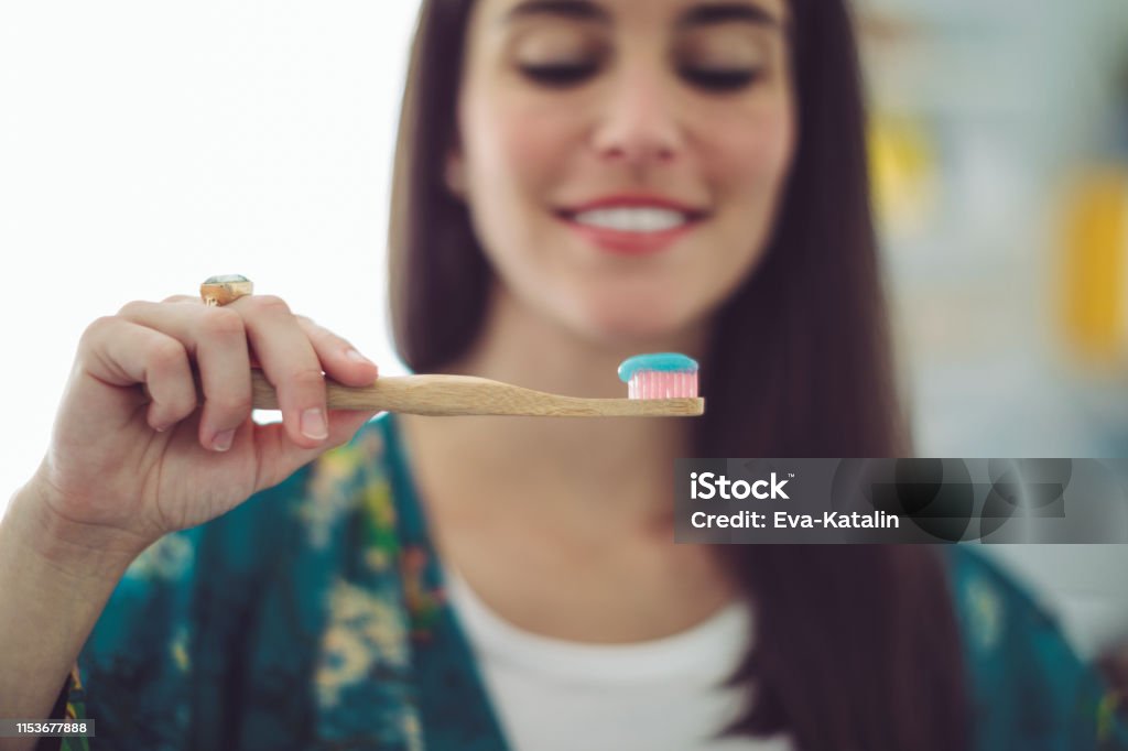 At home - young woman brushing her teeth Toothbrush Stock Photo