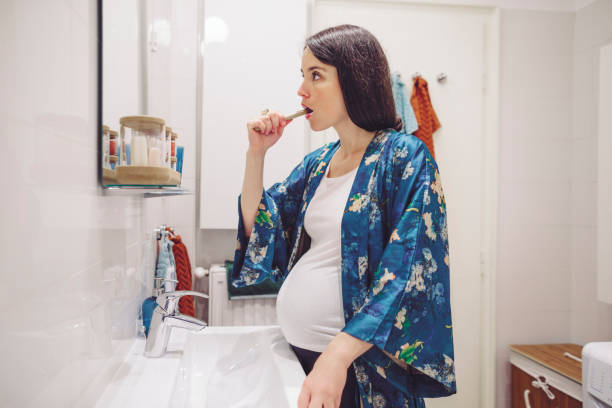 istock At home - young woman brushing her teeth 1153677898