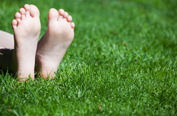 istock children girl foot grass background 1153678182