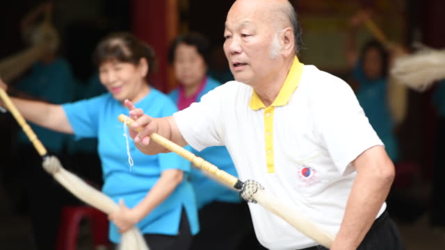 Master demonstrates TaiChi movement for seniors practicing