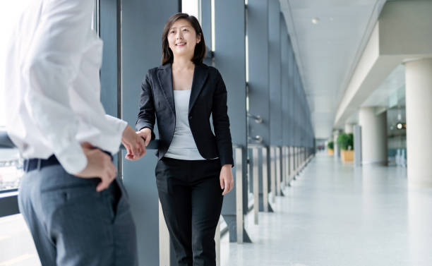 istock Two young business people chatting with each other at office corridor 1153682745