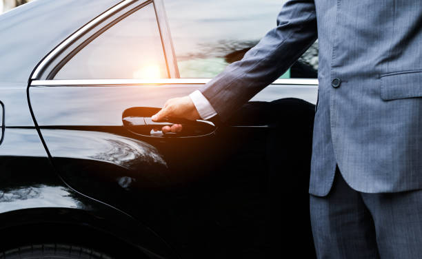 closeup of a doormans opening a car door - limousine imagens e fotografias de stock