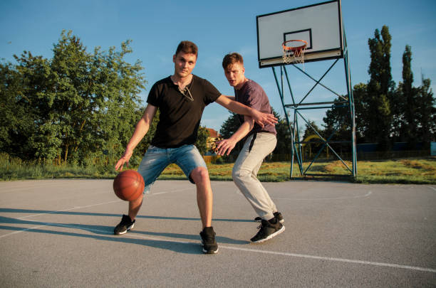 istock eens playing basketball outdoors court 1153684465