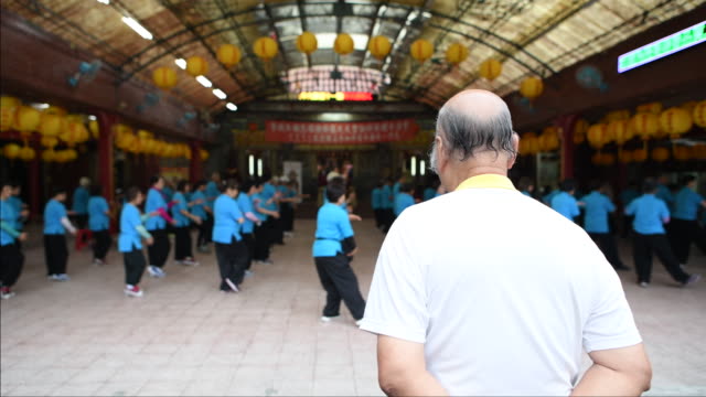 Senior Tai Chi Master watching senior students practice