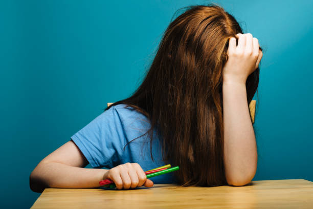 niespokojna młoda dziewczyna przy biurku - glasses child red hair little girls zdjęcia i obrazy z banku zdjęć