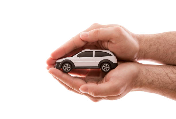 Car protection. Small white car covered by hands isolated on white background with clipping path stock photo