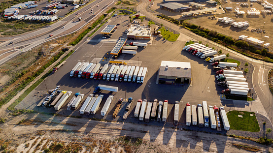 Aerial drone view of semis lined up in a row using tilt-shift making them look like toys