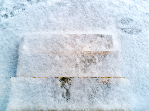 istock Stone steps. Staircase without railings. In the air first snow. Footprints on the first snow. The steps are icy, covered with snow. top view 1153684866