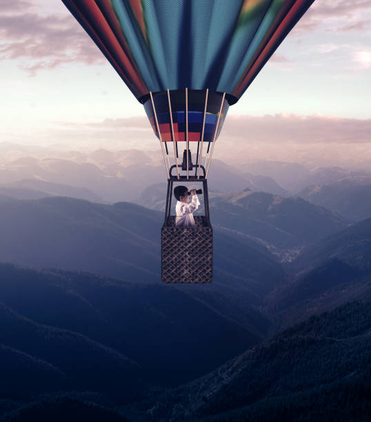 istock Man looks through binoculars flying with hot air balloon above mountains. 1153687244