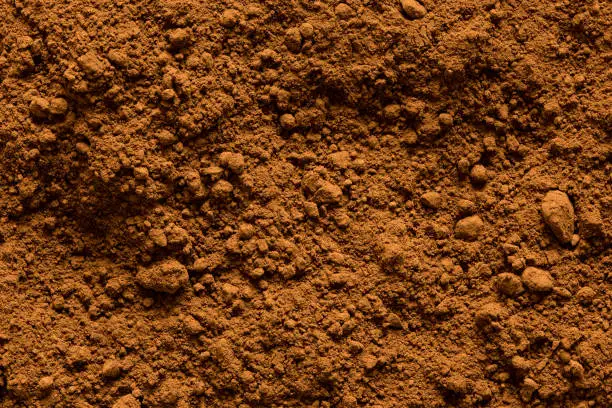 Background of ground cocoa powder from above.
