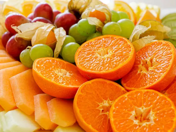 Mix of arranged freshly cut tropical and citrus fruit.