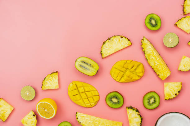 istock Table top view fruit tropical with spring summer holiday & vacation  background concept.Arrangement sliced various pineapple kiwi mango lemon and lime coconut on  pink paper.flat lay & copy space. 1153687928