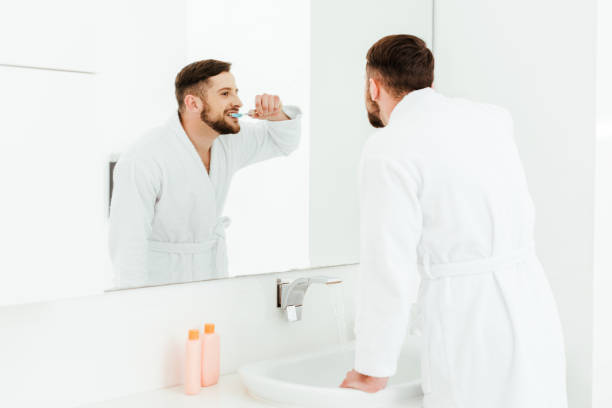 istock selective focus of handsome bearded man brushing teeth in bathroom 1153688523
