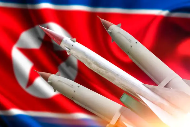 The rocket to launch. The flag of North Korea. Weapons of mass destruction. Missiles with warheads. Nuclear weapons, chemical weapons. War, fire, attack, threat.