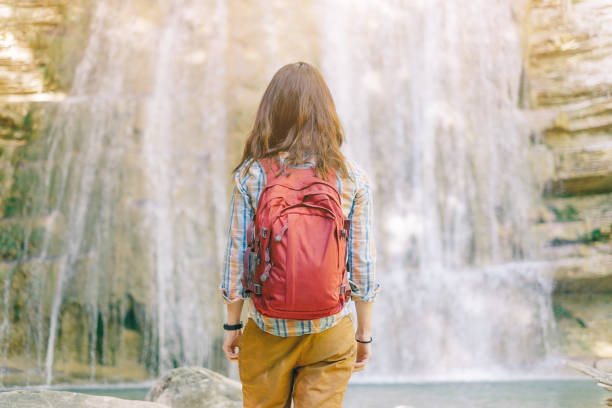 istock Hiker woman standing in front of waterfall. 1153689428