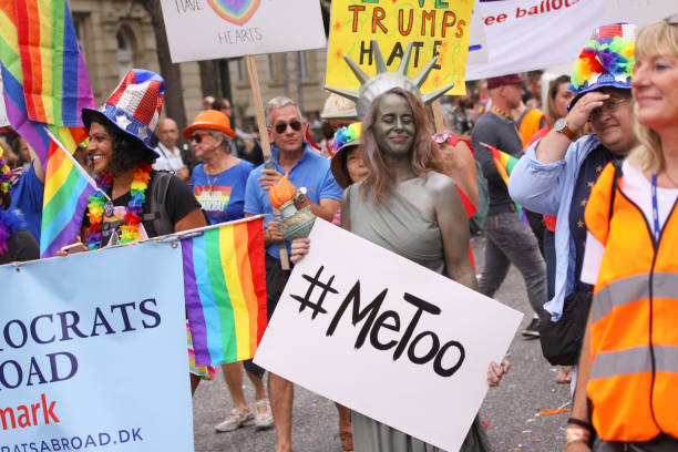 povos que prendem a bandeira que diz democratas no exterior na parada anual lgbt do orgulho. o homem vestiu-se como o tio sam e uma mulher vestida como a estátua da liberdade com sinal #metoo. impressões de gays e lésbicas participando da parada do orgu - me too movimento social - fotografias e filmes do acervo