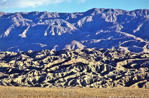 San Andreas Geologic Fault Line at sunrise in Coachella Valley near Palm Springs California USA.  In background the Little San Bernardino Mountains in Joshua Tree National Park.  Unusual abstract images in the erosion of rock and dirt rising at geologic fault epicenter.  Impressive example of tectonic forces.