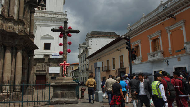 каменный крест, украшенный крестом из красных цветов, это традиция в кито во время страстной недели - quito ecuador ecuadorian culture town square стоковые фото и изображения