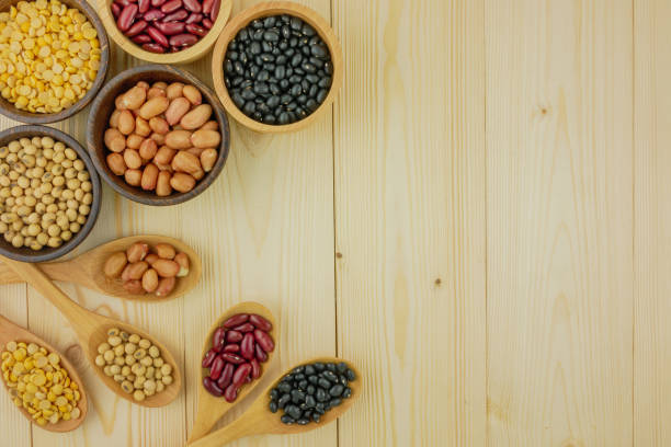 Flat lay,top view assorted beans including red bean,soybeans,black beans,mung beans on brown,beige wooden background with copy space