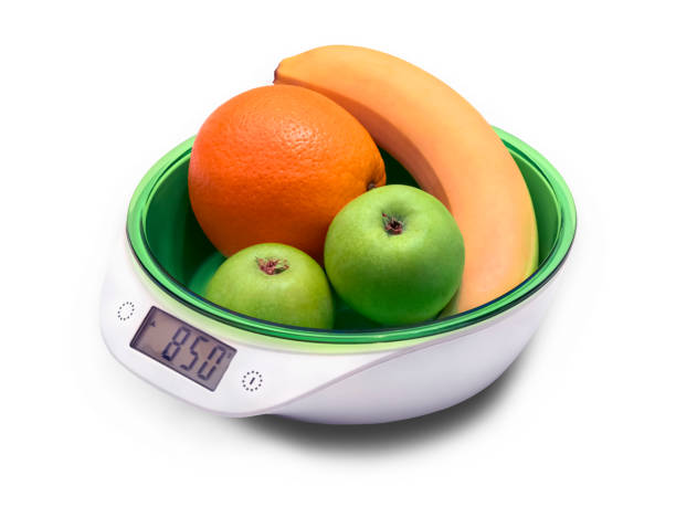 istock weighing fruit for diet on electronic scales. isolated on white 1153696671