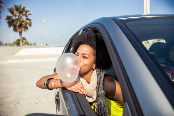 mujer jugando con chicle en un viaje por carretera - chewing gum women bubble blowing fotografías e imágenes de stock