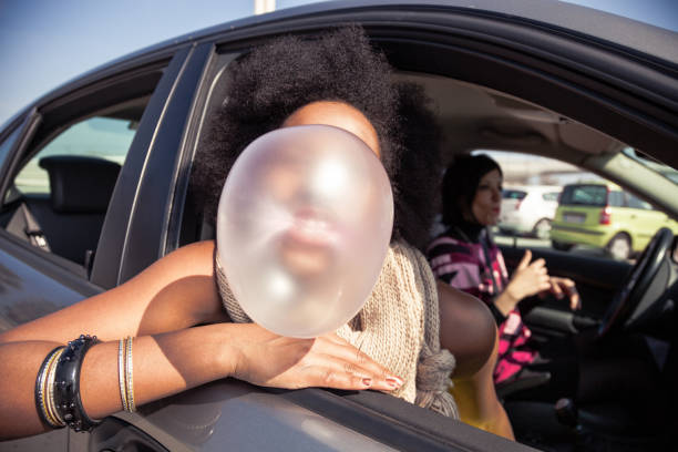 mujer jugando con chicle en un viaje por carretera - chewing gum women bubble blowing fotografías e imágenes de stock