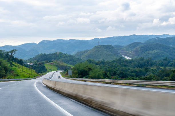 two lane street/ double lane road on dual carriageway highway through scenic countryside mountain landscape. - two lane highway fotos imagens e fotografias de stock