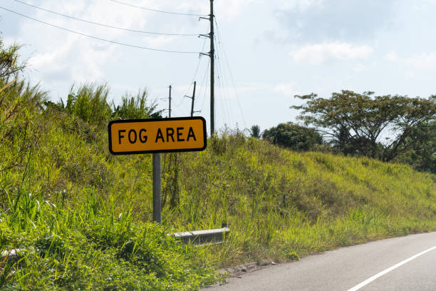 fog area caution traffic/street sign on highway through scenic countryside landscape. - two lane highway fotos imagens e fotografias de stock