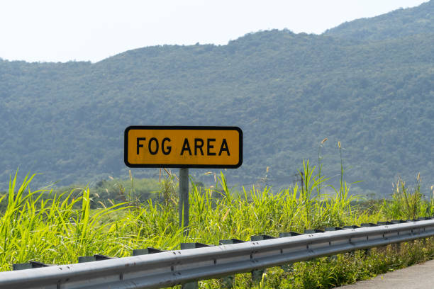 fog area caution traffic/street sign on highway through scenic countryside landscape. - two lane highway fotos imagens e fotografias de stock