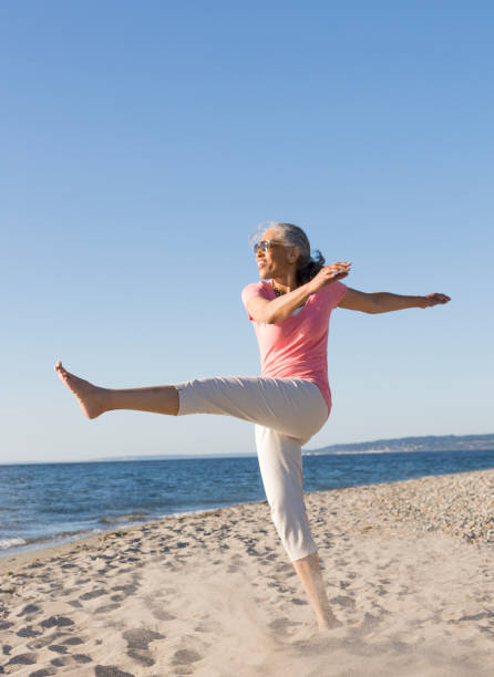 glückliche, im mittleren alter, schwarze, afroamerikanische amerikanerin, die im sommer eine sonnenbrille trägt, die sich am strand vergnügte. aktiver, gesunder, reifer lebensstil. - african descent healthy lifestyle people water stock-fotos und bilder