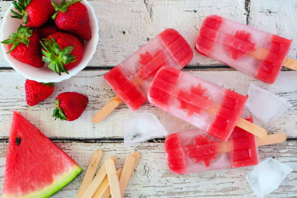istock Canada Day flag popsicles, top view on a rustic white wood table 1153706537