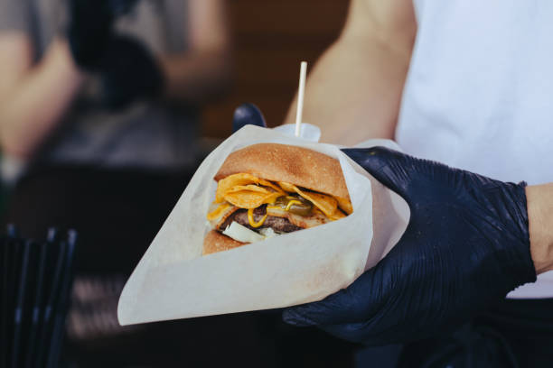 istock Cook preparing burger adding the sauce on the cream cheese. Three burgers. 1153707218