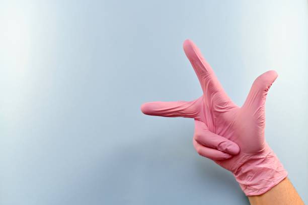 istock The right gloved hand shows three fingers. 1153707653