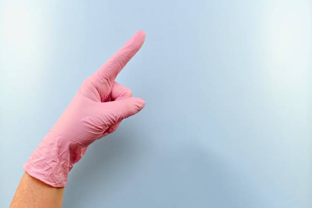 istock The index finger of a gloved hand points out. 1153707673
