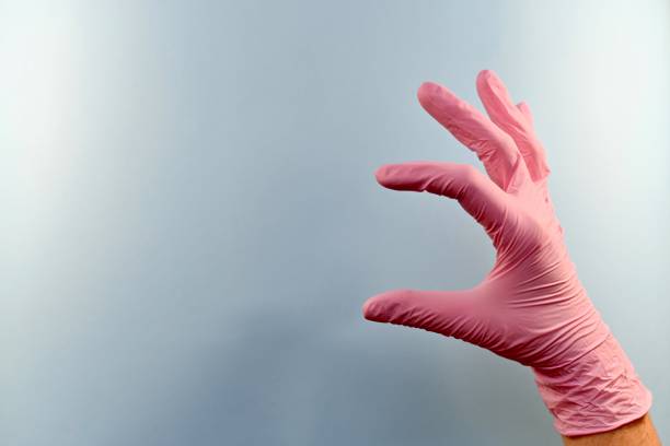istock One gloved hand is holding something or showing size. 1153707740