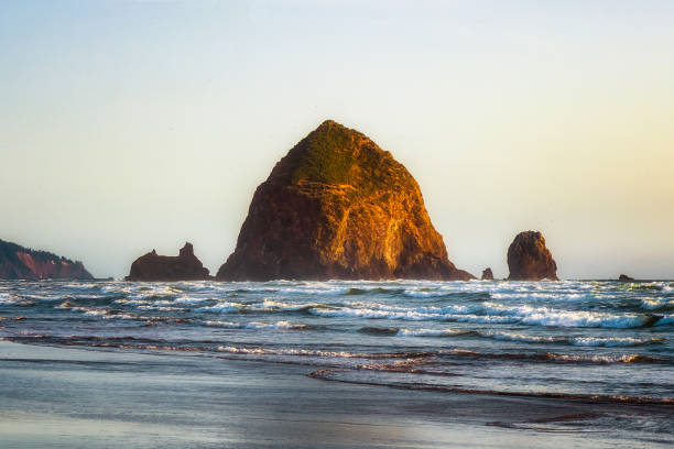 istock The Haystack Rock sea stack at high tide at sunset. Natural iconic landmark located in Cannon Beach, Oregon Coast, USA. 1153708794