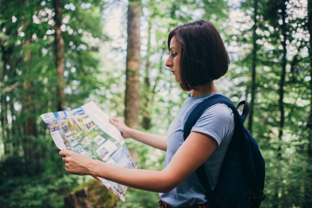 istock Woman looking at the map while hiking in forest. 1153709239