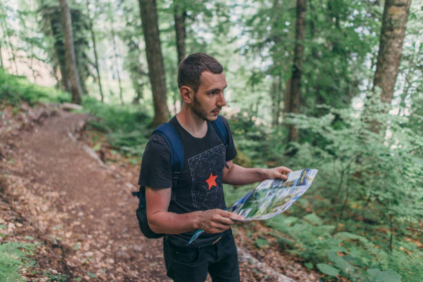 istock Hiker using a map to locate the destination in forest 1153709251