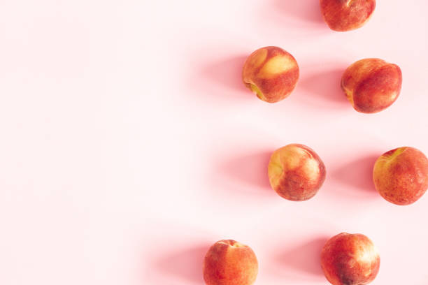 istock Peaches on pastel pink background. Frame made of fresh peaches. Flat lay, top view, copy space 1153710177