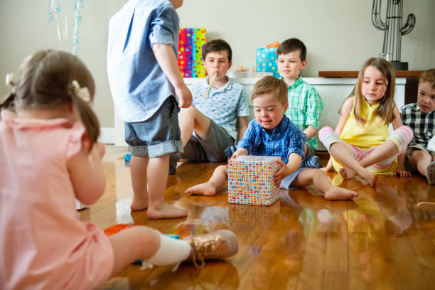 przyjęcie urodzinowe małego chłopca z zespołem downa - birthday present family facial expression birthday zdjęcia i obrazy z banku zdjęć