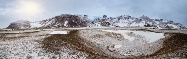 istock Panoramic view of Icelandic mountain range with glacier, crater to foreground 1153710375