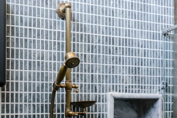 istock Unlacquered brass shower set, gray bathroom tile 1153713376
