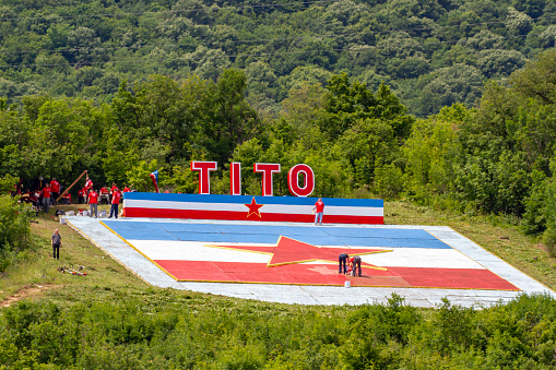 Novi Sip,  Serbia - May 26, 2019 :  Volunteers cleaning and painting monument to Tito in the Iron Gate gorges on the Danube River between Serbia and Romania.