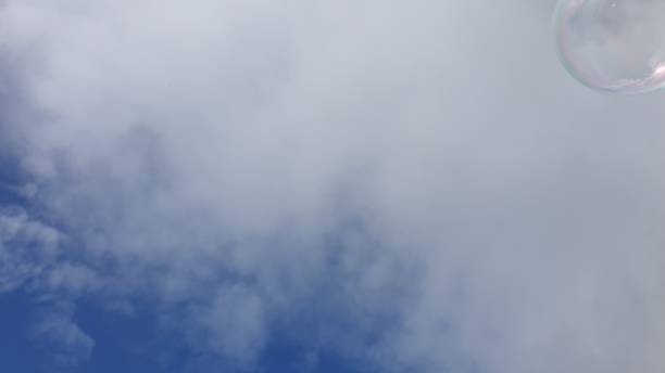 istock Soap bubble floating in blue sky with white clouds 1153714649