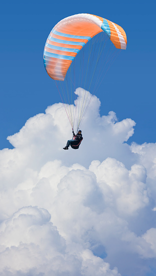 Paraglider flying parachute in the clouds