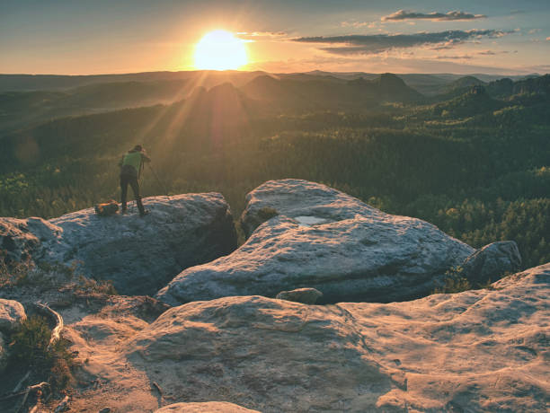 istock Photographer prepare equipment for taking photos on summit 1153719647