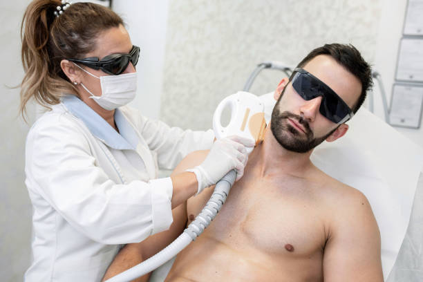 Young Man in Spa Salon Receiving Laser Epilation stock photo